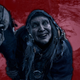 An edited screenshot shows Resident Evil Village's Old Hag smile creepily into the camera.